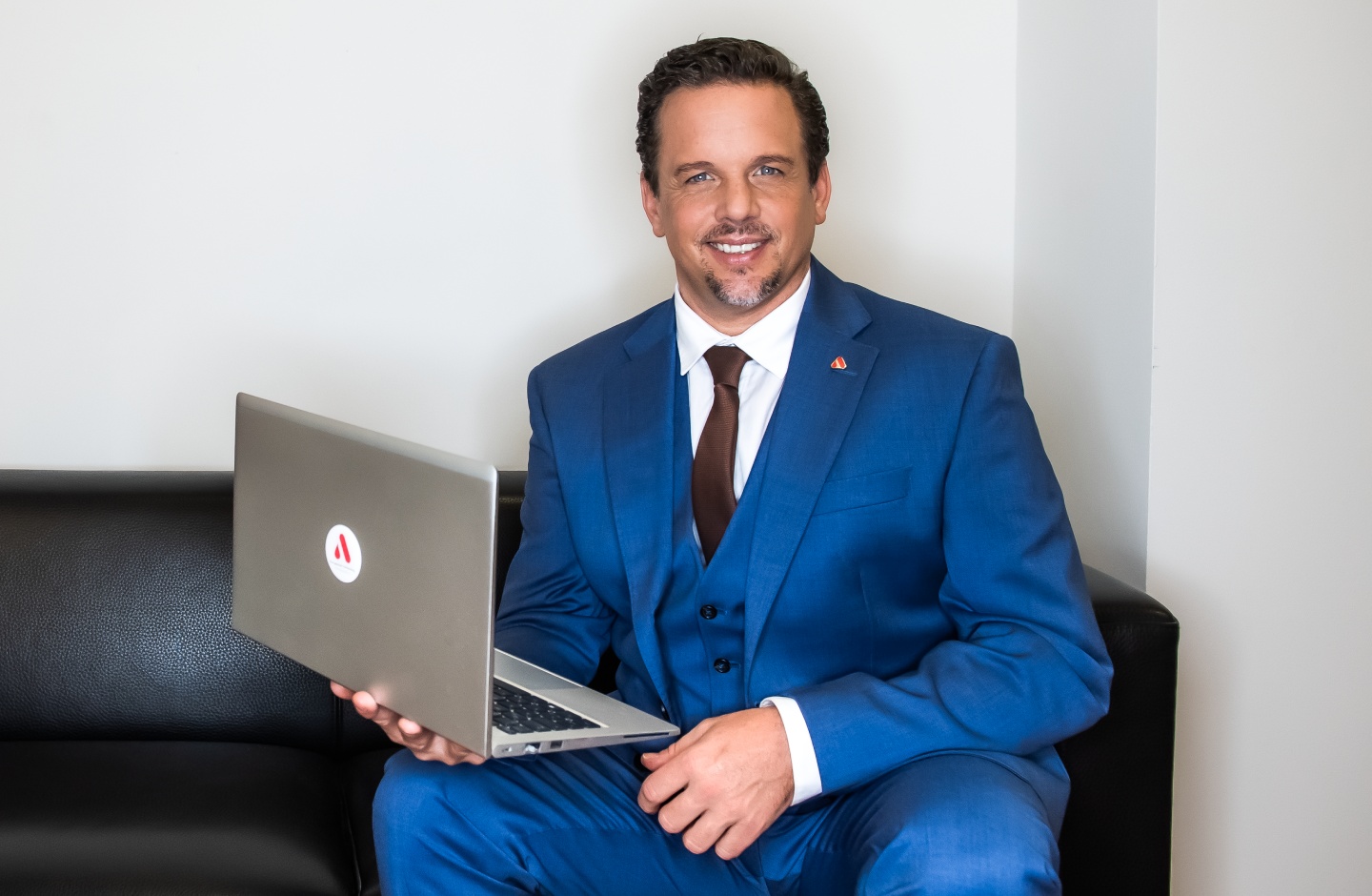 Mitarbeiter mit Laptop auf Sofa
